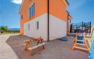 une aire de jeux avec des chaises en bois et un bâtiment dans l'établissement Stunning Home In Podpican With Outdoor Swimming Pool, à Gromnik