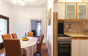 a kitchen and dining room with a table and a stove at Cozy Apartment In Banjole With Wifi in Banjole