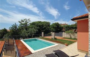 a swimming pool in the backyard of a house at Cozy Home In Umag With Wifi in Murine