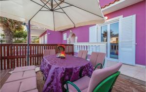a purple table with chairs and an umbrella on a deck at Pet Friendly Apartment In Mundanije With House A Panoramic View in Mundanije