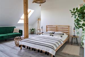 een slaapkamer met een bed en een groene bank bij Nad Wyspą in Lubycza Królewska +20 foto's