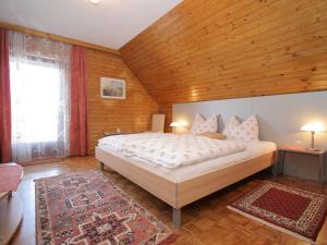 ein Schlafzimmer mit einem großen Bett und einer Holzdecke in der Unterkunft Cozy apartment in Eberndorf Carinthia near the Petzen ski area in Eberndorf