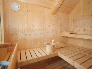 een houten sauna met een emmer en een klok bij Chalet in Hohentauern with in house wellness in Hohentauern