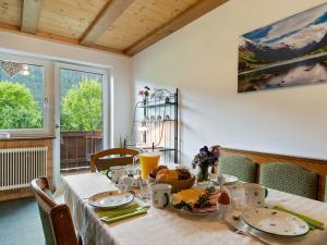 una mesa de comedor con un mantel blanco y comida. en Cosy Apartment in M hlbach with Balcony en Dorf