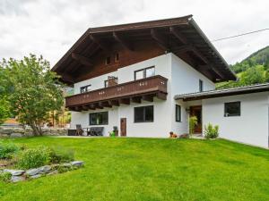 dom z zielonym trawnikiem przed nim w obiekcie Chalet Bramberg near Ski Slopes w mieście Dorf