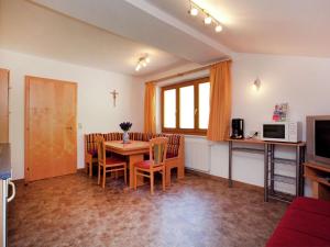 una sala da pranzo con tavolo, sedie e TV di Beautiful Apartment in Wagrain near Ski Area a Wagrain