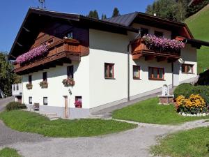Biały dom z kwiatami na oknach w obiekcie Apartment in Wagrain near Red 8 Gondola w mieście Wagrain