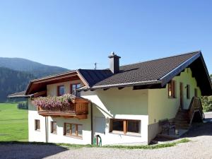 Biały dom z balkonem i kwiatami w obiekcie Apartment in Wagrain near Red 8 Gondola w mieście Wagrain +34 zdjęcia