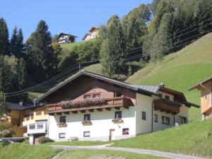 dom w górach z kwiatami na oknach w obiekcie Apartment in Wagrain near Red 8 Gondola w mieście Wagrain