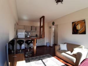sala de estar con sofá y cocina en Alquiler Departamento Centro Mendoza Capital en Mendoza