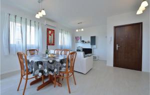 a dining room and living room with a table and chairs at 2 Bedroom Gorgeous Apartment In Privlaka in Nin
