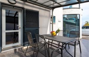 una mesa y sillas en un patio con ventana en Nice Apartment In Vrh With 1 Bedrooms, Wifi And Outdoor Swimming Pool en Vrh