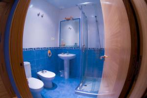 a bathroom with a toilet and a sink and a shower at Hotel el Horreo de Avilés in Avilés