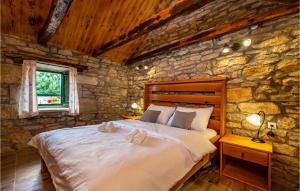 1 dormitorio con 1 cama grande en una pared de piedra en Gorgeous Home In Zelengrad With Kitchen en Zelengrad