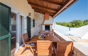 un patio con mesa, sillas y chimenea en Gorgeous Home In Lovrecica With Kitchen en Lovrečica