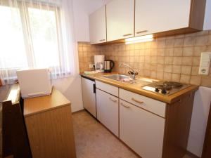 une petite cuisine avec évier et comptoir dans l'établissement Apartment in Wagrain near the ski area, à Wagrain