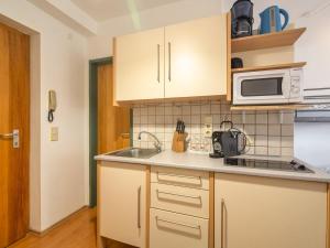 eine Küche mit einer Spüle und einer Mikrowelle in der Unterkunft Ski in ski out apartment at Nassfeld in Carinthia in Sonnenalpe Nassfeld