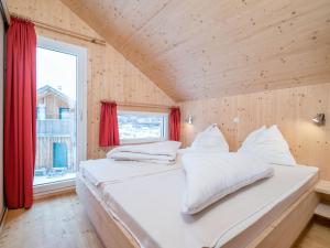 Cette chambre comprend un grand lit blanc et une fenêtre. dans l'établissement Chalet in Hohentauern with sauna and hot tub, à Hohentauern