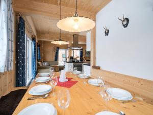 une salle à manger avec une grande table et des verres à vin dans l'établissement Chalet in Hohentauern with sauna and hot tub, à Hohentauern