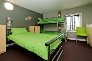 a room with two bunk beds and a green bed at YHA Berwick in Berwick-Upon-Tweed