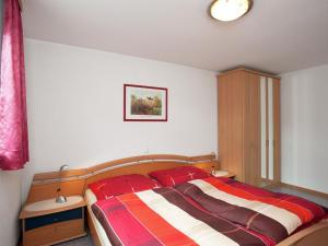 a bedroom with a bed with a red and white blanket at Apartment near the ski area in Vandans in Vandans