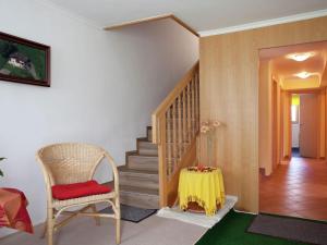 ニーダーンジルにあるApartment near Zell am See Kaprunの椅子とテーブル付きの階段が備わる客室です。