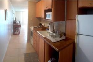 a kitchen with a white refrigerator and a sink at Cond. Marina Lanais in Fajardo