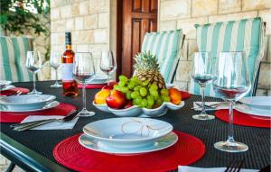 a table with plates and bowls of fruit and wine glasses at Nice Home In Lokva Rogoznica With 4 Bedrooms, Wifi And Outdoor Swimming Pool in Lokva Rogoznica