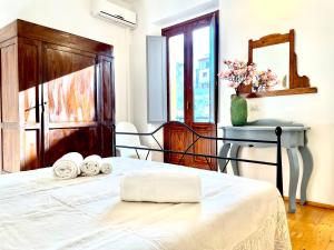 a bedroom with a bed with two rolled towels on it at Le Corti Sarde Apartments in Bari Sardo