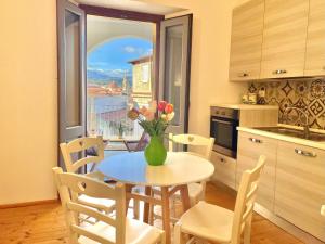 a kitchen with a table with a vase of flowers on it at Le Corti Sarde Apartments in Bari Sardo