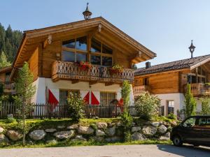 dom z balkonem i samochód zaparkowany przed budynkiem w obiekcie Chalet in Wald near Wildkogel Ski Arena w mieście Wald im Pinzgau