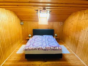 um quarto com uma cama num quarto de madeira em Holiday apartment in Salchau near ski area 