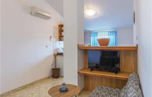 a living room with a tv and a table at Gorgeous Apartment In Barban-rebici With Kitchen in Rebići