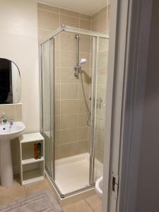 W łazience znajduje się prysznic i umywalka. w obiekcie The Strand Guest House w mieście Falcarragh