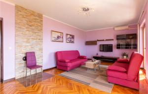 sala de estar con 2 sillas rosas y TV en Nice Apartment In Novi Vinodolski With Wifi, en Novi Vinodolski