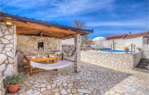 a patio with a hammock and a stone wall at Pet Friendly Home In Sveti Vid With Outdoor Swimming Pool in Sveti Vid-Miholjice