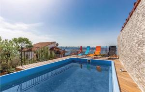a swimming pool with chairs next to a building at Lovely Apartment In Crikvenica With Outdoor Swimming Pool in Crikvenica
