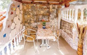 a table and chairs in a room with a stone wall at Lovely Apartment In Crikvenica With Outdoor Swimming Pool in Crikvenica