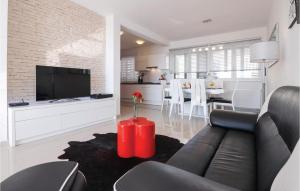 a living room with a black couch and a red table at Amazing Home In Novigrad With Sauna in Novigrad Dalmatia
