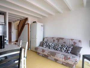 a living room with a couch and a refrigerator at Appartement T3 Bord de plage in Biscarrosse-Plage