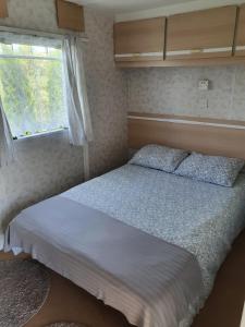 a bedroom with a bed and a window at Bałtyckie Zacisze - Domki holenderskie w Bobolinie, ul Darlowska 11a in Dąbki