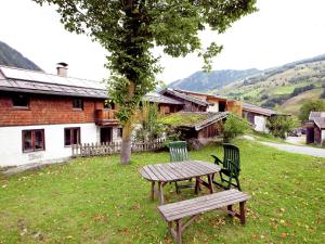 a picnic table and two chairs sitting in the grass at Lovely Holiday Home in Rauris with Terrace in Rauris