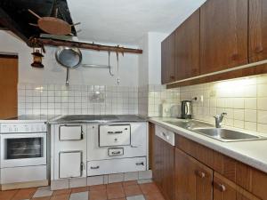 eine Küche mit weißen Geräten und einem Waschbecken in der Unterkunft Lovely Holiday Home in Rauris with Terrace in Rauris