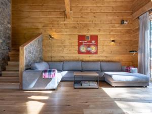a living room with a blue couch and wooden walls at Chalet in Tauplitz with sauna in ski area in Tauplitz