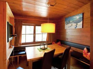 ein Esszimmer mit einem Holztisch und einem TV in der Unterkunft Spacious Chalet near Ski Slopes in Worgl in Bad Häring