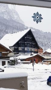 un grande edificio con neve sul tetto di SUPERBE APPARTEMENT T2 3 ETOILES 40m2 PIED DES PISTES VUE SUR LE LAC a Thollon