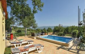 una piscina con due sedie a sdraio accanto di Gorgeous Home In Dicmo With Outdoor Swimming Pool a Jadrići