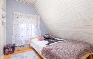 a bedroom with a bed with pink pillows on it at Nice Home In Begovo Razdolje With Wifi in Begovo Razdolje