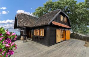 une petite maison noire avec des portes en bois sur une terrasse dans l'établissement 6 Bedroom Amazing Home In Jastrebarsko, à Jastrebarsko