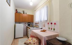 a kitchen with a table and a white refrigerator at Nice Apartment In Banjole With Wifi in Banjole